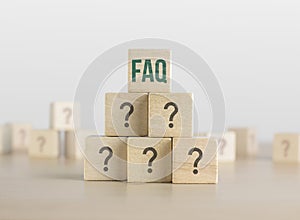 FAQ, Q and A or Problem solving concept. Wooden blocks with question mark icon arrangedÂ in pyramid stairÂ shape and a man is